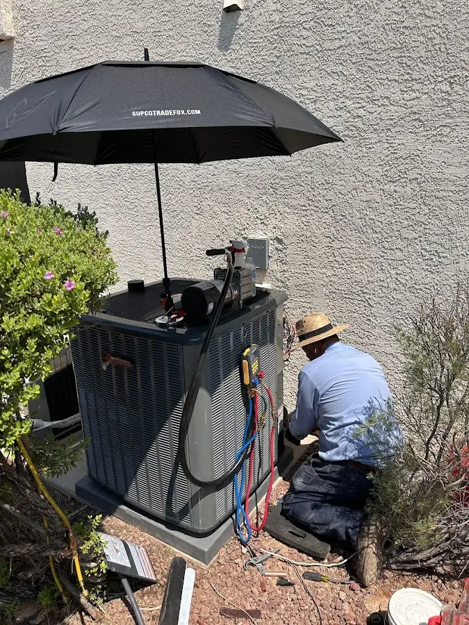 HVAC technician performing outdoor AC maintenance in Buckeye